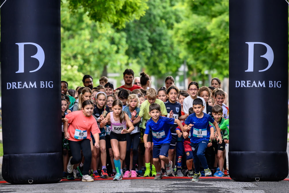 Kinder starten gemeinsam zu einem Lauf unter dem Startbogen beim Sportfest Move & Groove.