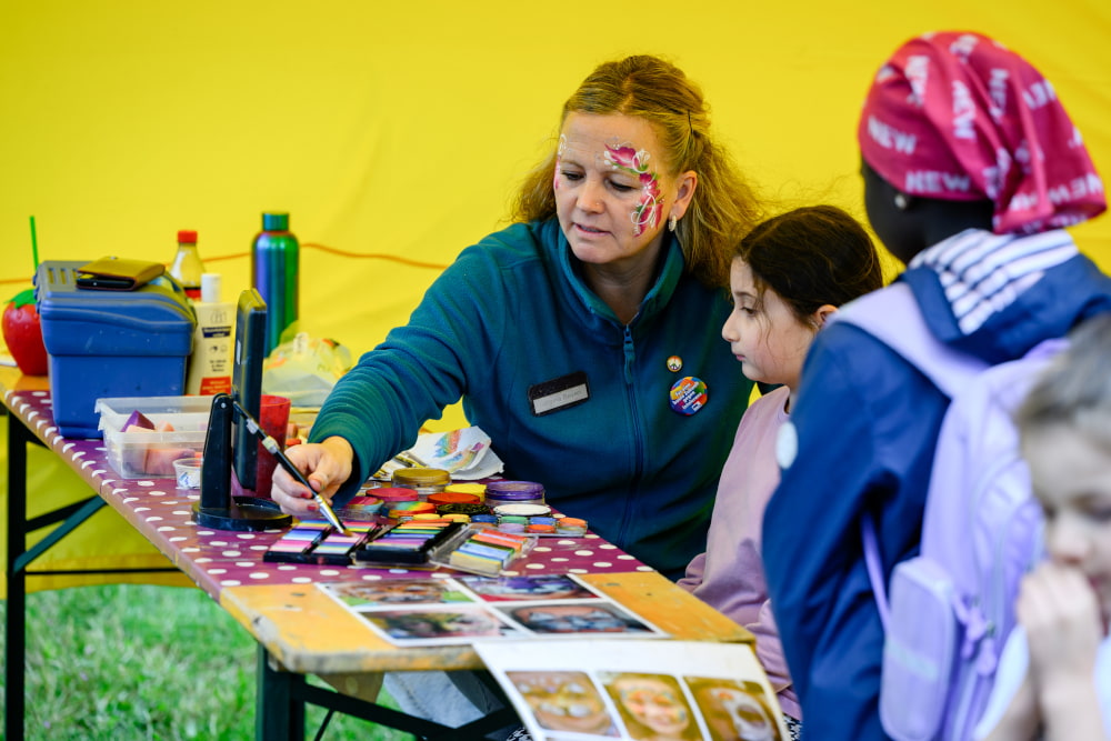 Kind lässt sich beim Kinderschminken während des Sportfests Move & Groove bemalen.