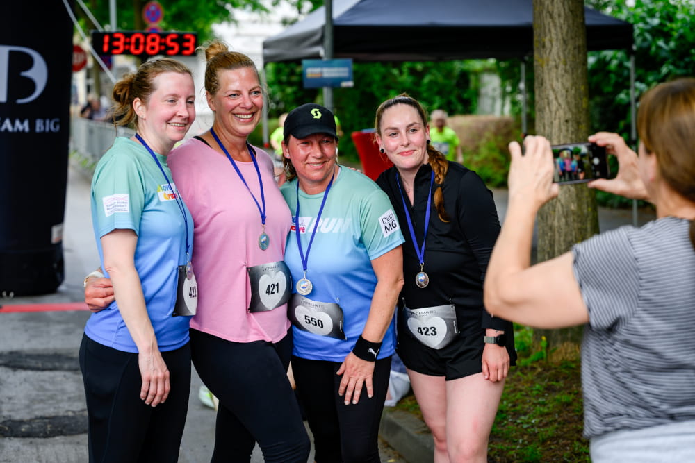 Teilnehmende mit Medaillen machen nach dem Lauf ein Erinnerungsfoto beim Sportfest Move & Groove.