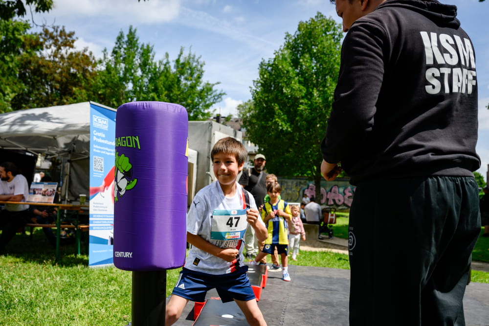 Kind probiert an einer Boxstation seine Schlagkraft beim Sportfest Move & Groove aus.