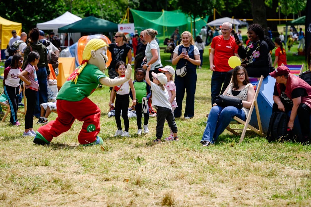 Das Maskottchen Jolinchen der AOK begrüßt Kinder beim Sportfest Move & Groove.