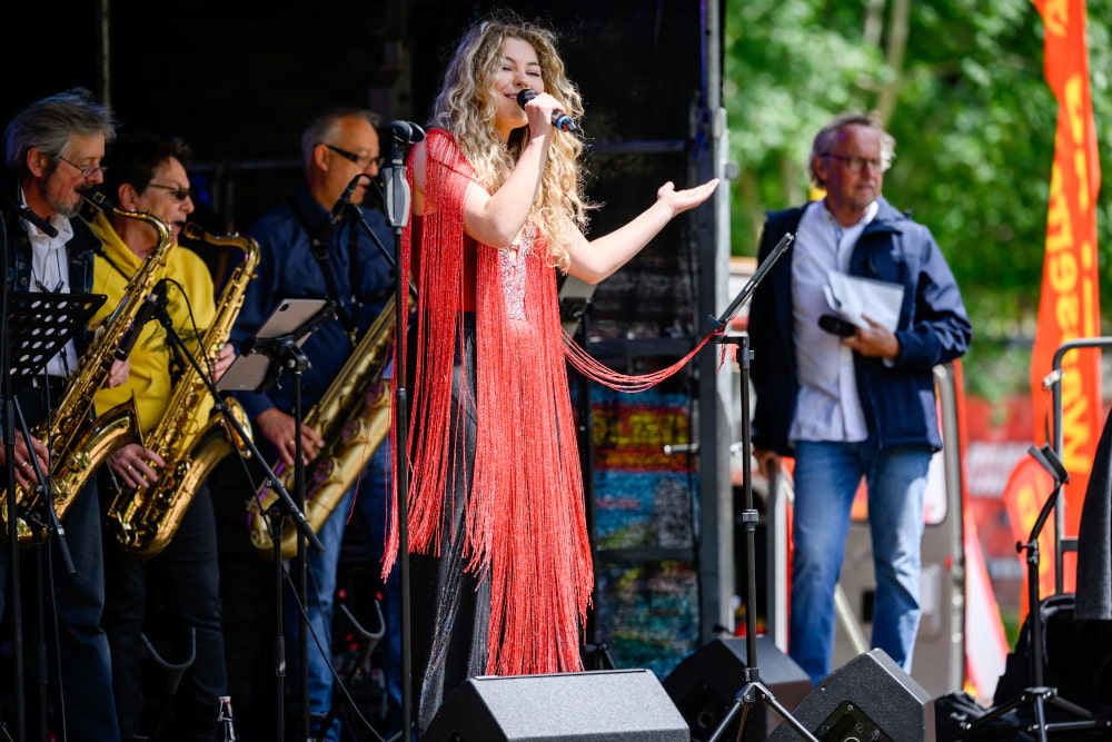 Sängerin tritt mit Liveband auf der Bühne beim Sportfest Move & Groove auf.